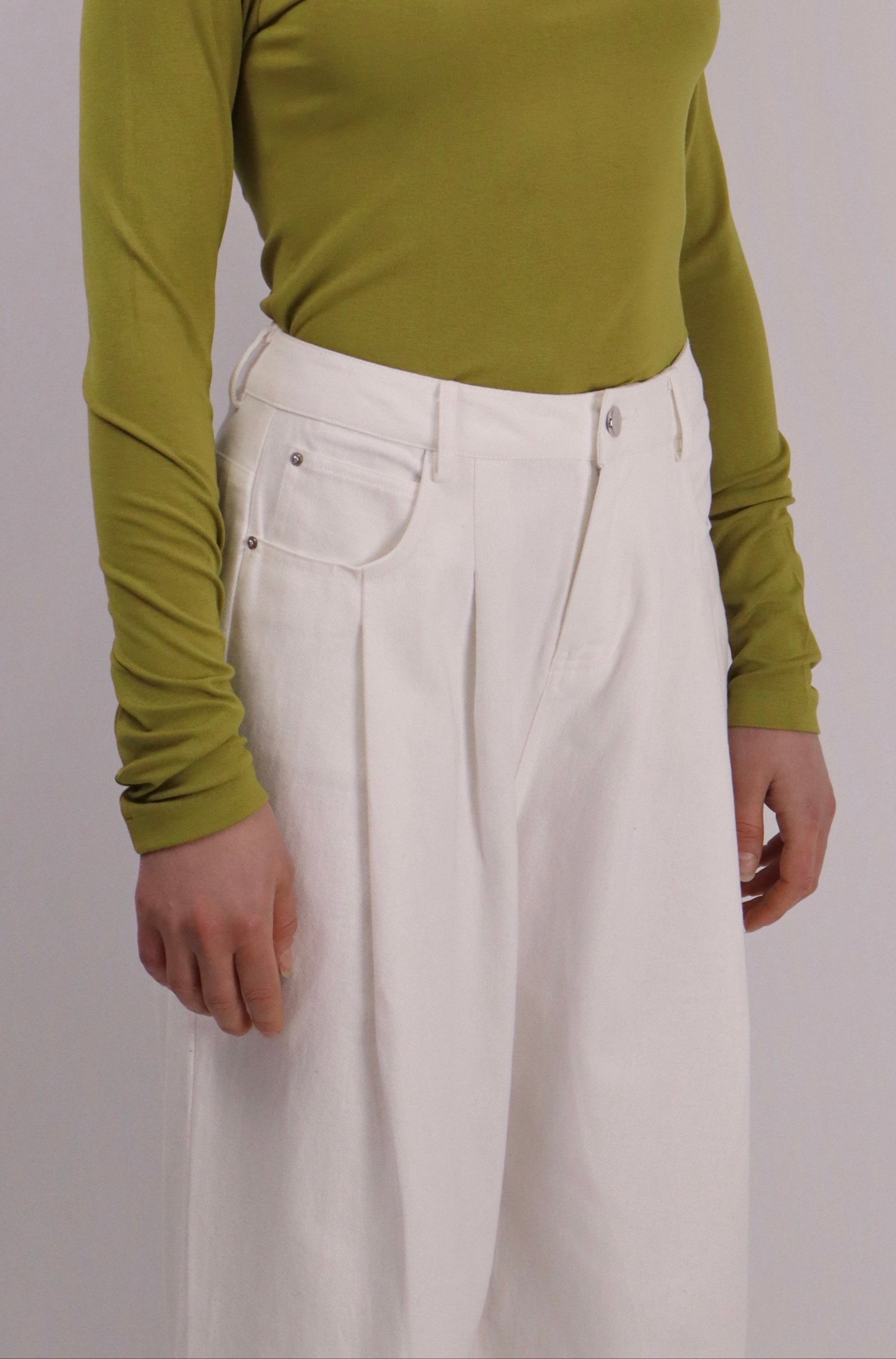 Model wearing a slim-fit long-sleeve modal knit top with oversized pleat detail on one shoulder, in mocha, paired with white sandals