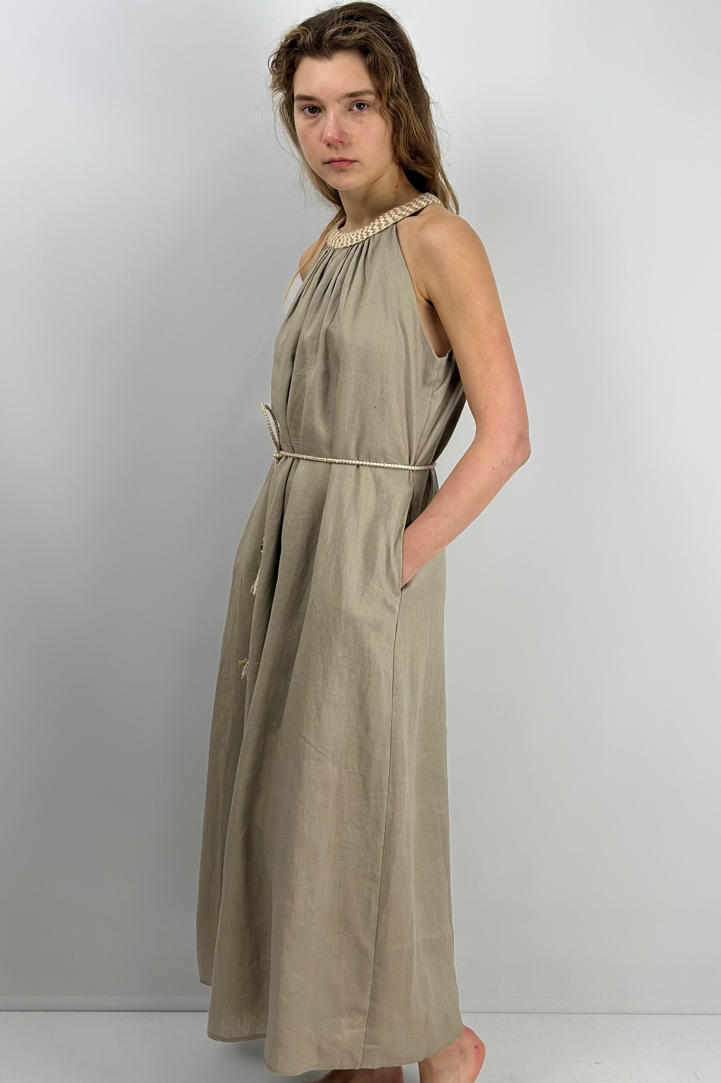 Woman wearing a maxi linen dress against a white background