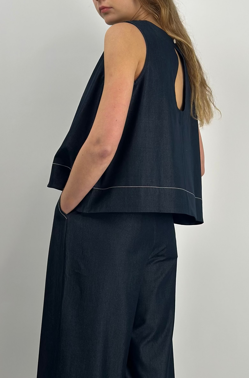 Woman wearing a navy sleeveless top and wide-leg pants