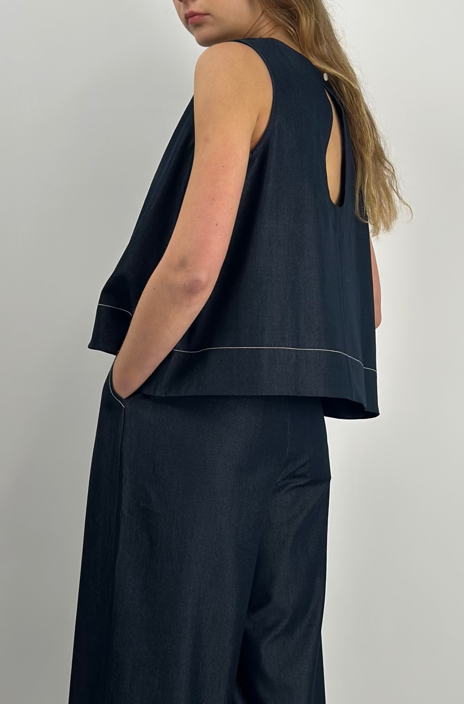 Woman wearing a navy sleeveless top and wide-leg pants