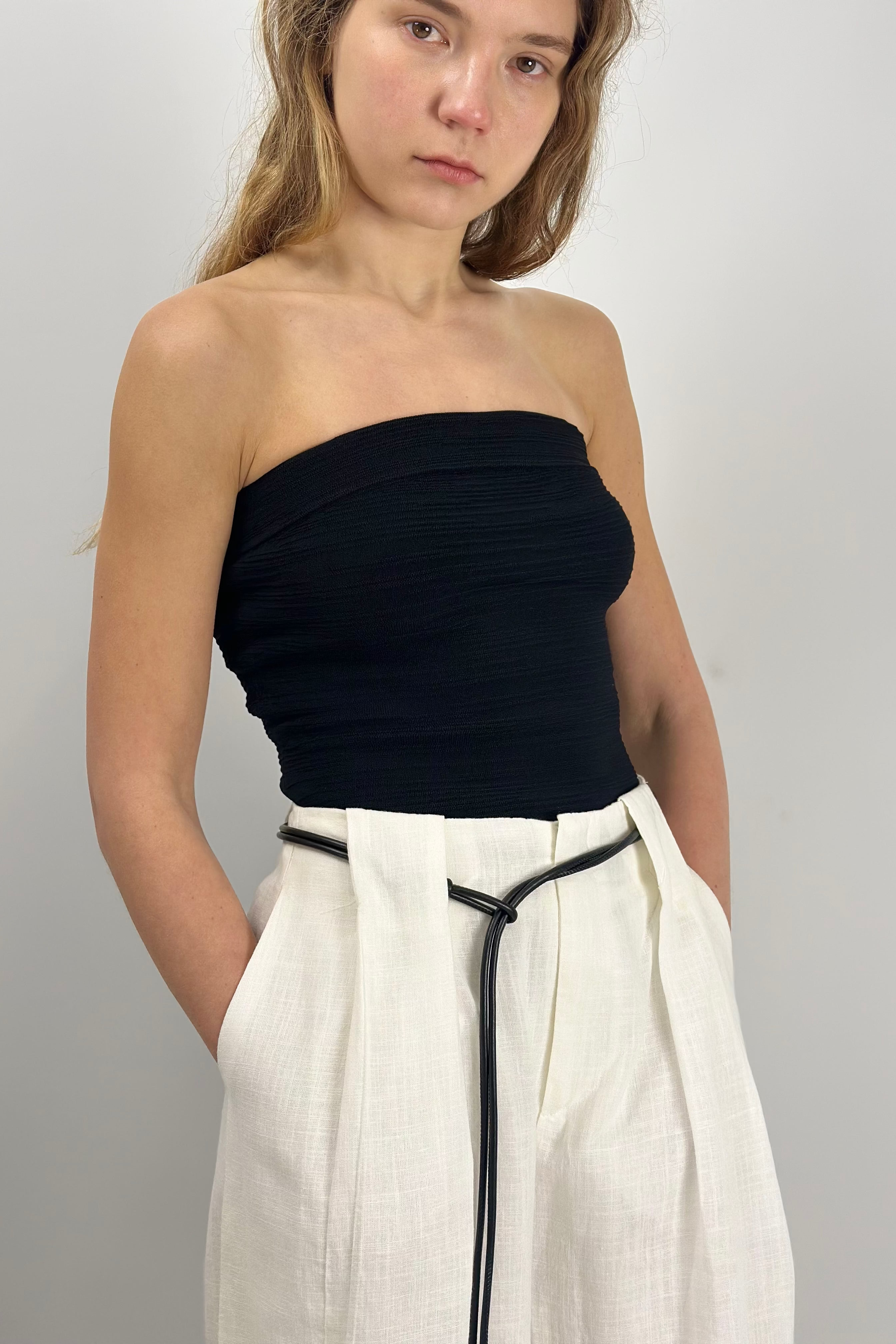A sleek strapless tube top with subtle ruching for a flattering, body-contouring fit. Its stretch finish enhances comfort and movement, while the minimalist design makes it a versatile piece for both casual styling and refined layering.
